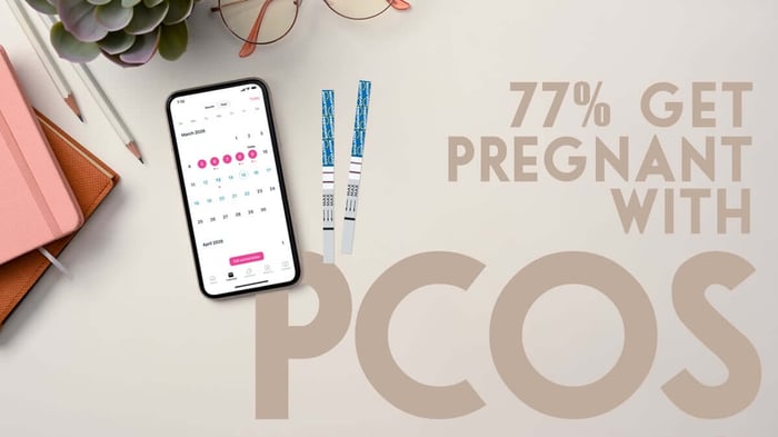 Ovulation test strips next to a smartphone fertility tracking calendar illustrating how women with PCOS track ovulation to improve chances of pregnancy