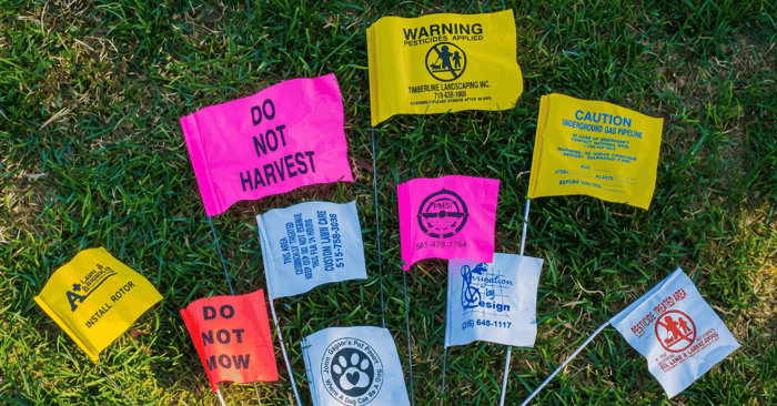 array of different sized marking flags laying flat in the grass