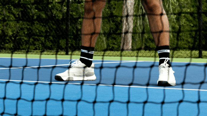 Pickleball shoes behind a net