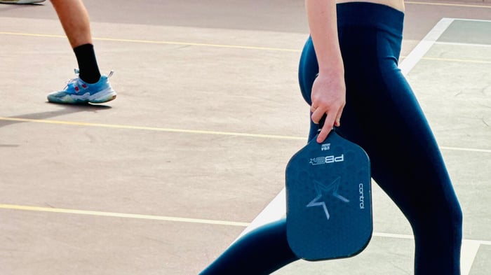 Pickleball player walking across the court