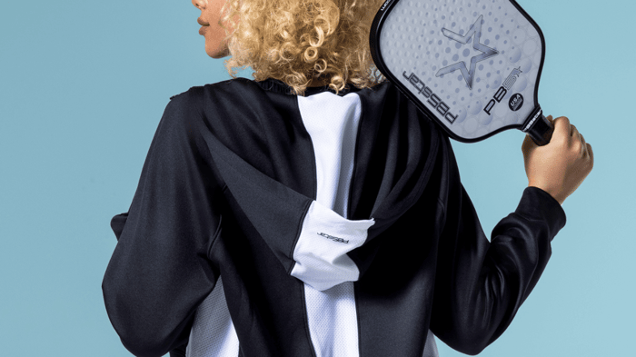 Pickleball player holding a paddle over should