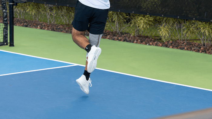 Pickleball player jumping on a court