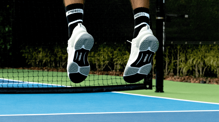 Pickleball player jumping on a court