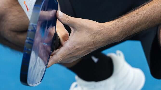 Close up shot of man holding pickleball racket