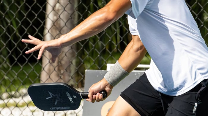 Close up shot of man's hand holding a pickleball racket