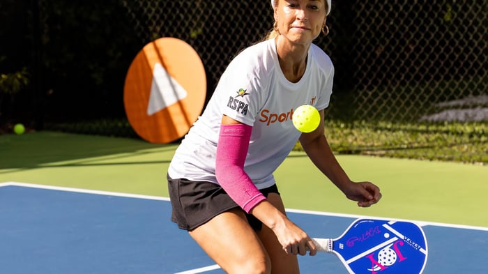 Female pickleball player about to hit a shot