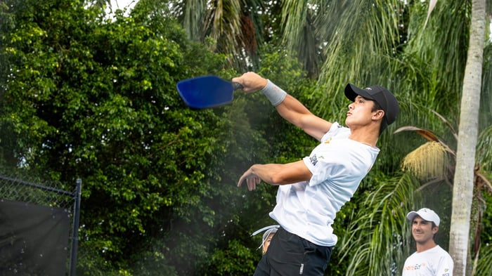Pickleball player jumping to return the ball