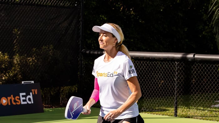 Woman preparing to receive a serve during pickleball match