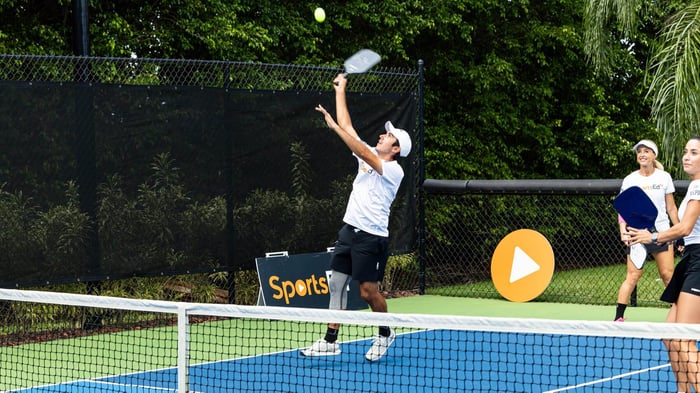 Man jumping to hit a pickleball