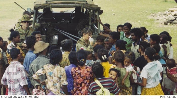 A crowd of Timorese gather around an Australian medical clinic held in an Army land rover, 17 November 1999.