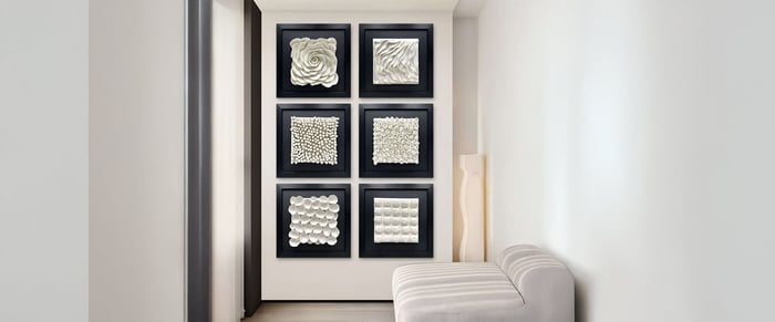 Six square 3D floral panels displayed in a hallway with black frames and white textures, adding depth and elegance to the wall.