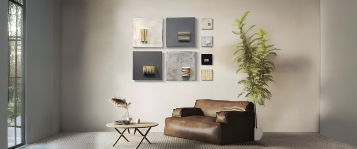 Wabi Sabi Art collage with abstract mixed media panels above a leather armchair in a minimalist living room.