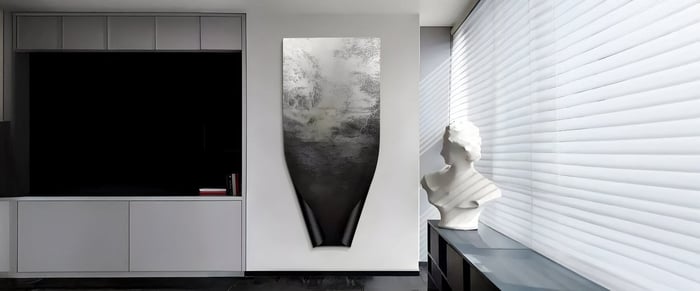 A contemporary living room features a striking round canvas art piece depicting a canyon landscape with golden hills and a cascading waterfall, framed in soft metallic hues—an elegant balance of nature and modern design.