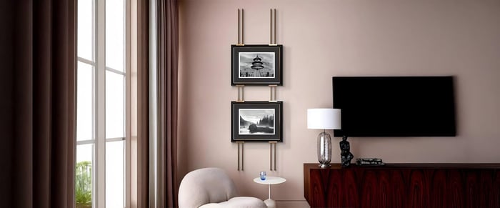 Neutral-toned living space with stacked black-and-white framed photos and a sleek modern TV setup.