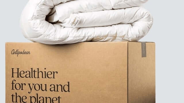 Wool vs bamboo duvets comparison – folded white wool comforter on neutral background showing natural breathable bedding materials