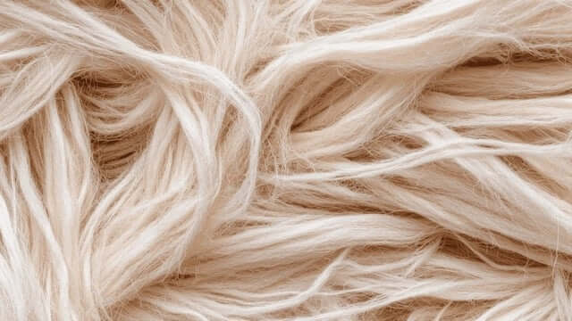 Folded white natural fiber bedding made from cotton with a soft, breathable texture