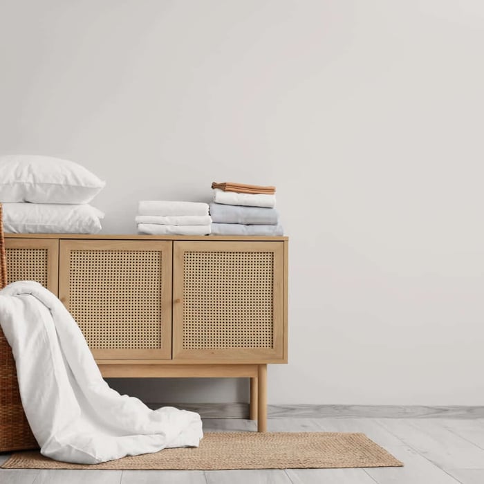 Bright modern bedroom with a neatly made bed styled with cooling sheets designed to keep sleepers comfortable and temperature-balanced.