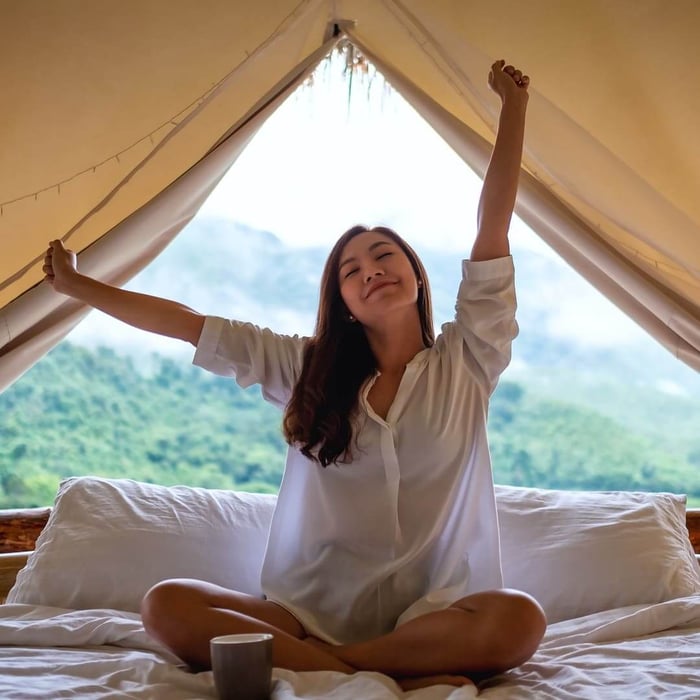 why does my comforter make me sweat — woman waking up cool and refreshed with natural breathable bedding