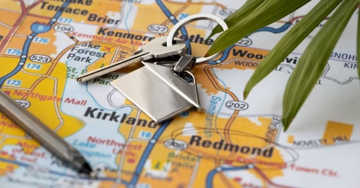 high angle of a key and pen laying on map with cities in the best states to live in circled