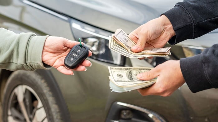 Seller handing over keys after learning how to sell a car fast in Minnesota on CarSoup
