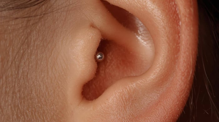 Close up of ear with tragus piercing for migraines