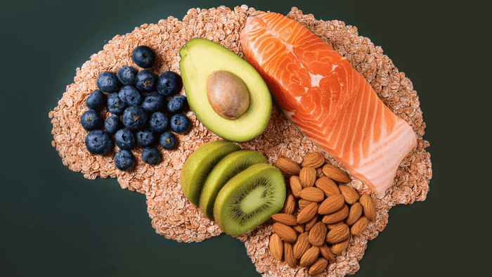 Brain shaped arrangement of healthy foods including salmon avocado blueberries kiwi and almonds