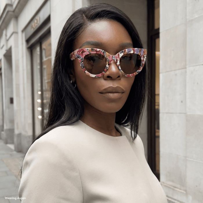 Acetate sunglasses example featuring a woman wearing luxury ANEA HILL acetate sunglasses with a bold, colorful frame in a city setting