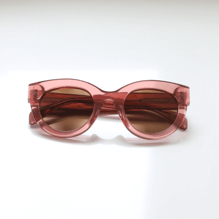 Luxury sunglass trends 2025 exemplified by Anea Hill pink translucent round sunglasses with brown lenses