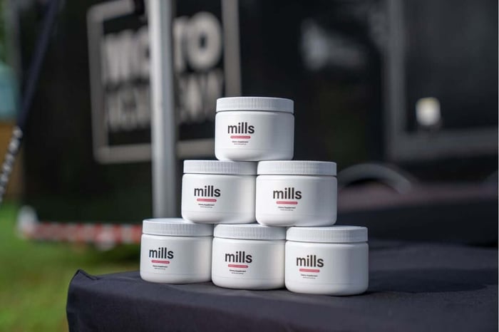 Mills raspberry lemonade electrolyte powder stacked on the Moto Academy trailer table at a 5-Day Camp.