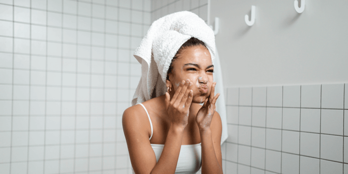Young child washing face with childrens face washers while learning the difference between a childrens face cleanser and the best face wash for kids