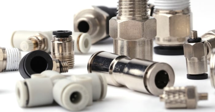 Assorted metal and plastic pneumatic air hose fittings, including threaded adapters and push-to-connect couplers.