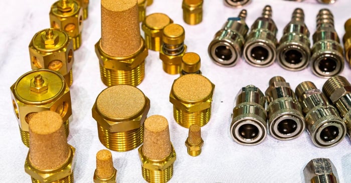 Assorted brass pneumatic mufflers and metal air fittings, showing various sizes and threaded designs.