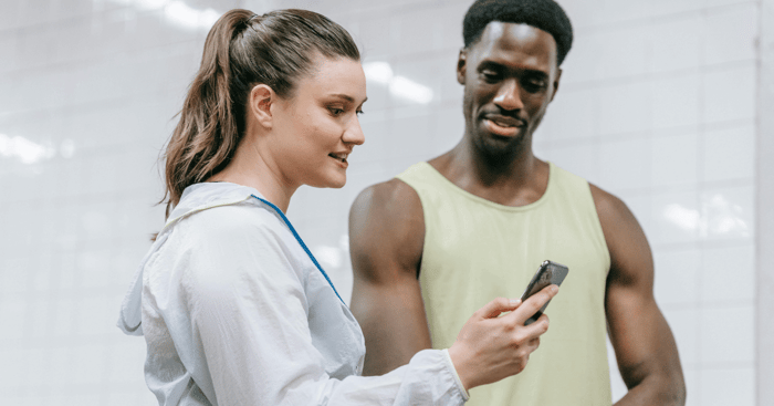 Personal trainers looking at their phone