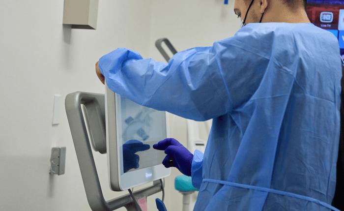 A dentist working on a monitor