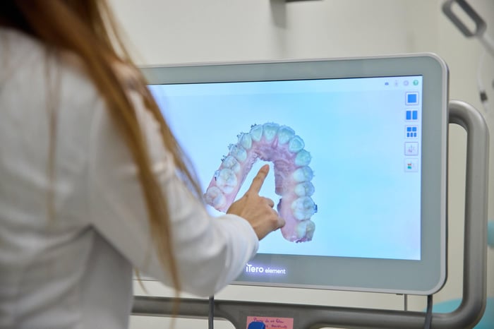 A woman pointing to a monitor
