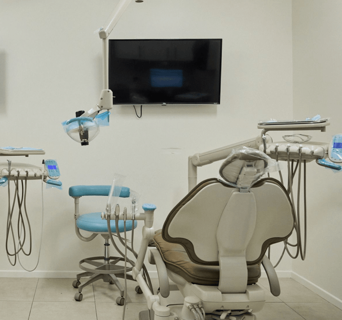 A dental chair in front of a monitor