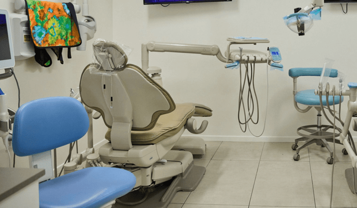 A dental chair in front of a monitor