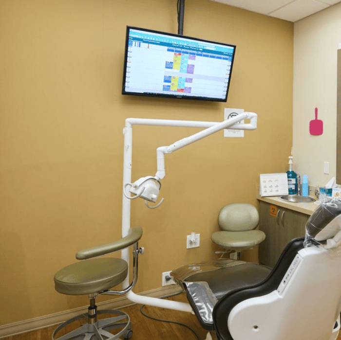 A dental chair in front of a monitor