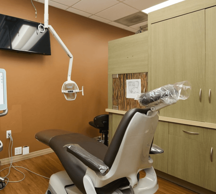 A dental chair in front of a monitor