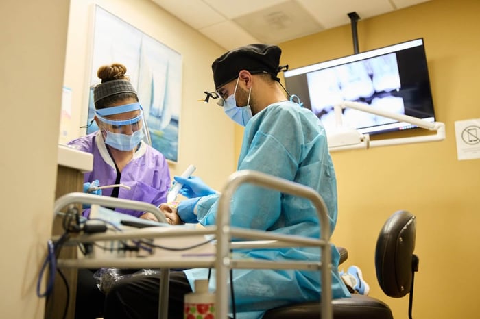 A dentist and an assistant working on a patient