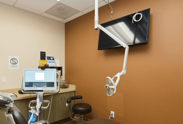 A dental chair in front of a monitor