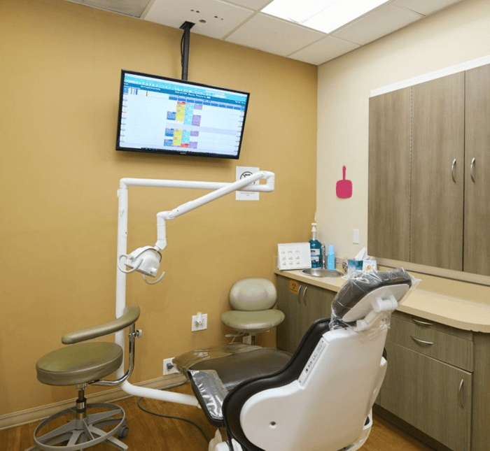 A dental chair in front of a monitor