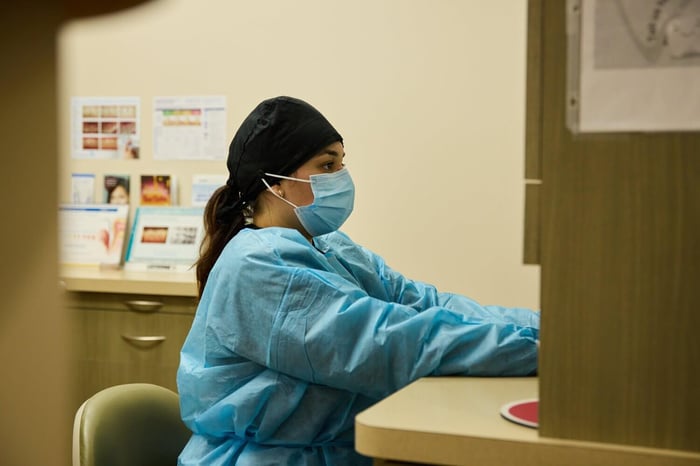 A woman sitting while wearing a face mask
