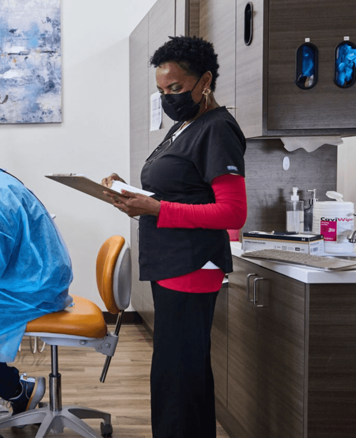 A woman standing holding a clipboard