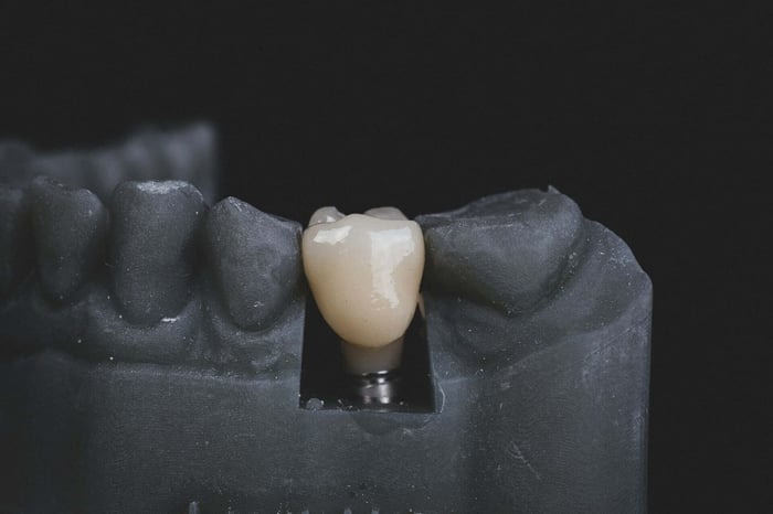 A tooth surrounded by black rubber teeth