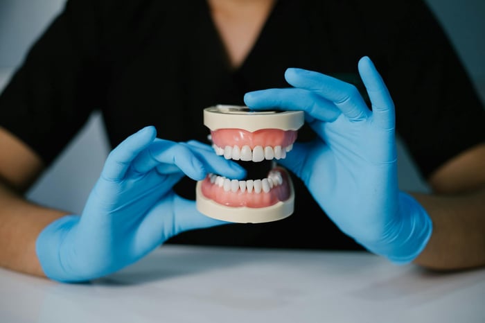 A person holding a set of dentures