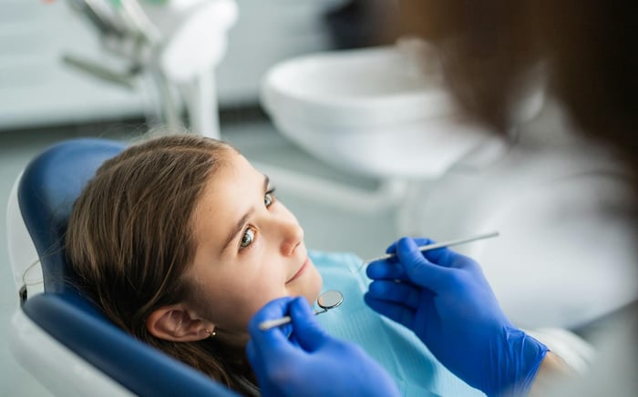 A girl looking at a dentist