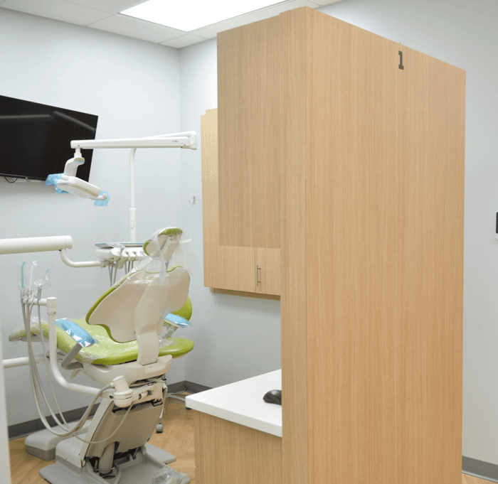 A dental chair in front of a monitor