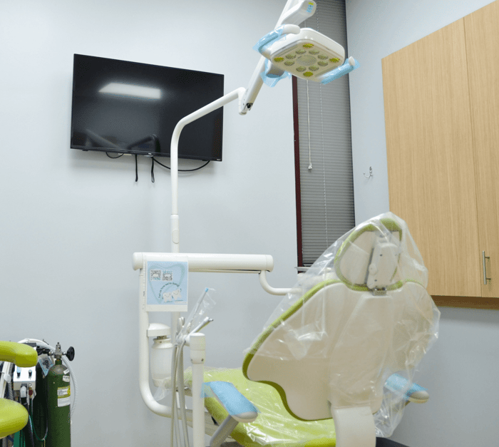 A dental chair in front of a monitor