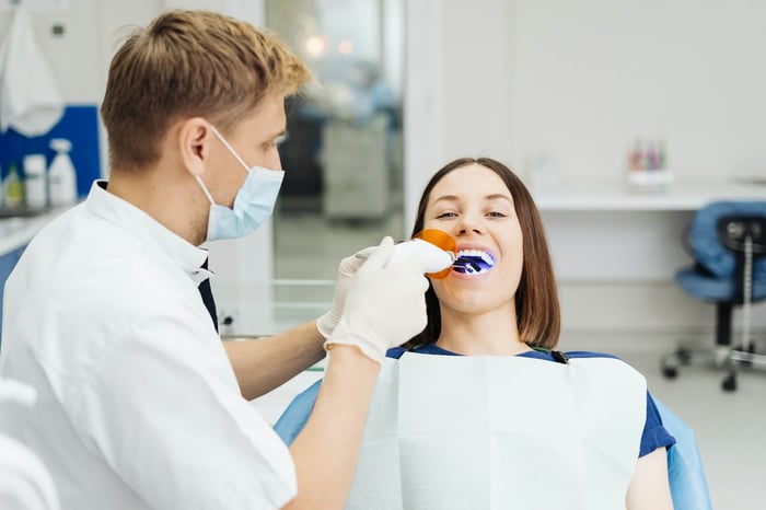 A person working on a patient's teeth